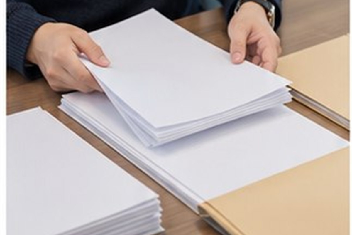 강제집행정지 신청방법 관련 글자가 보이지 않는 법률 서류와 빈 파일을 날짜순으로 정리하는 손