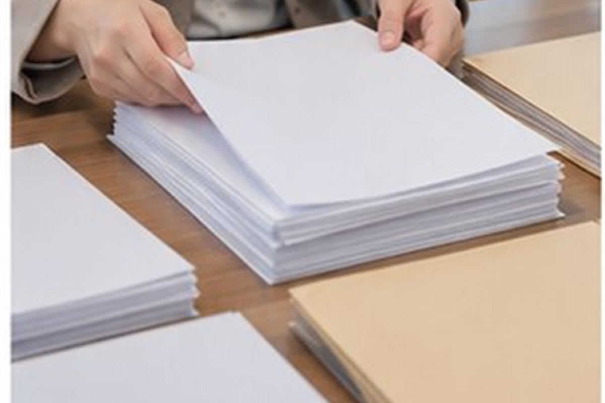 부동산강제경매 신청비용 관련 글자가 보이지 않는 법률 서류와 빈 파일을 날짜순으로 정리하는 손