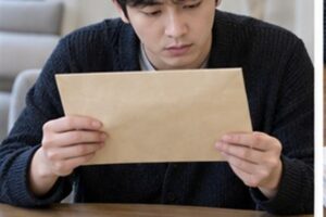 내용증명 반송 효력, 상대가 받지 않으면 통지가 무효가 될까 2 내용증명 반송 효력 관련 반송된 등기우편 봉투를 확인하는 한국인 성인, 봉투에 글자와 라벨 없음
