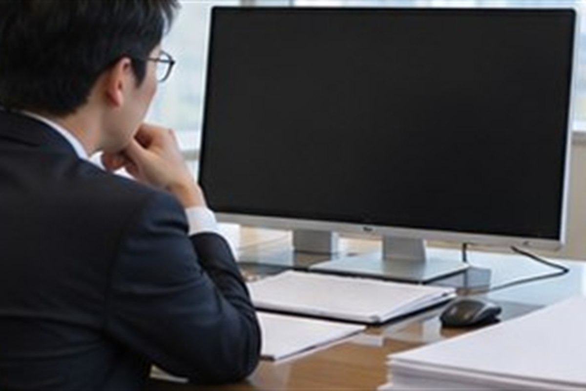 주식회사해산등기 관련 기업 행정 담당자가 컴퓨터와 빈 문서로 등기 일정을 점검하는 사무실