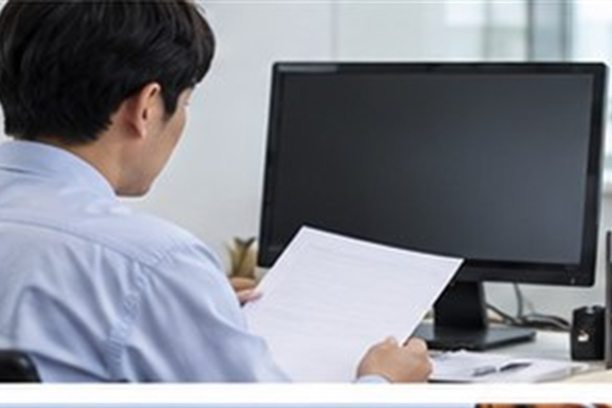 전환사채발행등기 관련 기업 행정 담당자가 컴퓨터와 빈 문서로 등기 일정을 점검하는 사무실